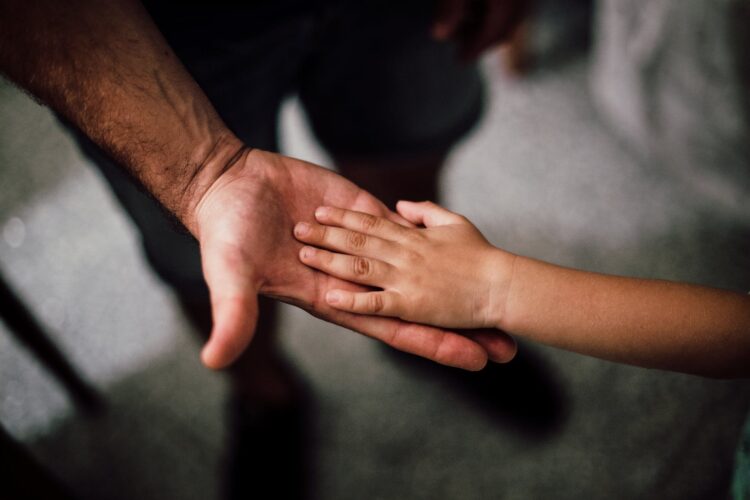 selective focus photography of child s hand